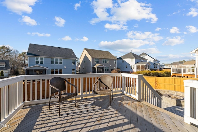 wooden deck with fence, a residential view, and an outdoor fire pit