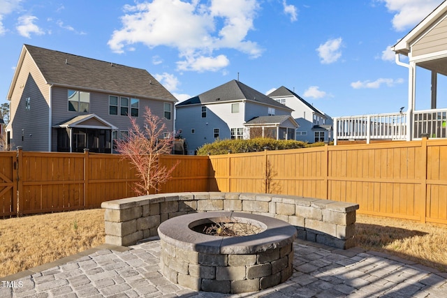 view of patio / terrace featuring a residential view, a fenced backyard, and an outdoor fire pit