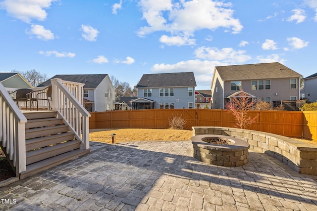 view of patio / terrace featuring a fenced backyard, a residential view, and a fire pit