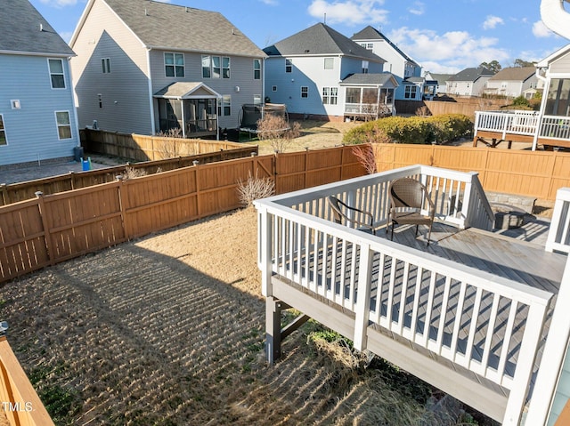 view of yard featuring a residential view, a wooden deck, and a fenced backyard