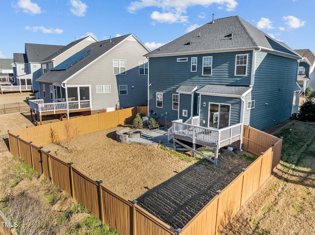 rear view of house with a fenced backyard, a residential view, roof with shingles, and a wooden deck