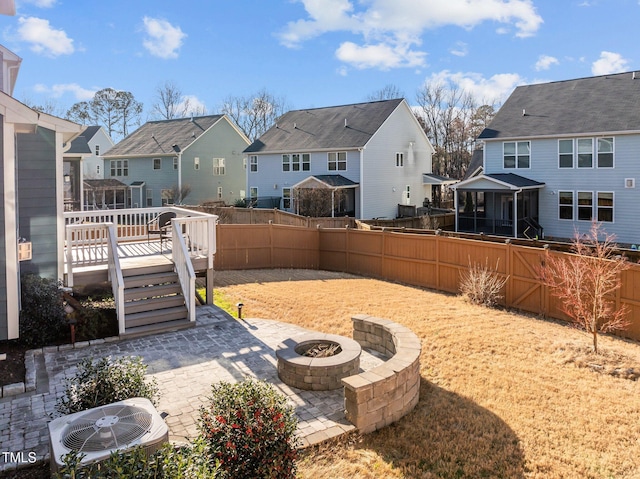 view of yard with central air condition unit, a fenced backyard, a residential view, and an outdoor fire pit