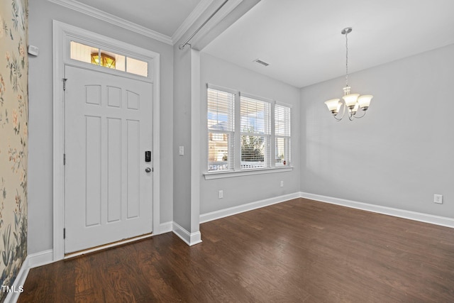 foyer with dark wood-style floors, visible vents, baseboards, crown molding, and a chandelier