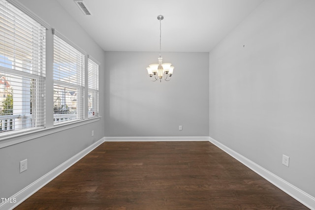 unfurnished dining area featuring a notable chandelier, baseboards, dark wood-type flooring, and visible vents