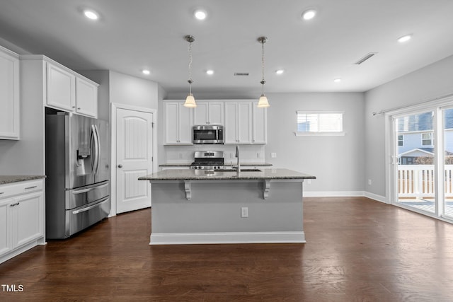 kitchen featuring dark wood finished floors, visible vents, stainless steel appliances, and light stone countertops