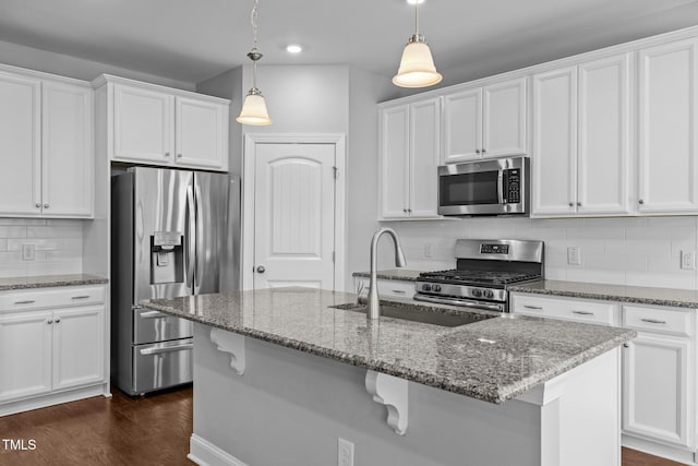 kitchen with backsplash, dark wood finished floors, white cabinets, stainless steel appliances, and a sink