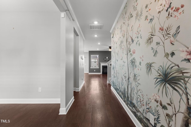 corridor with wood finished floors, visible vents, baseboards, recessed lighting, and ornamental molding