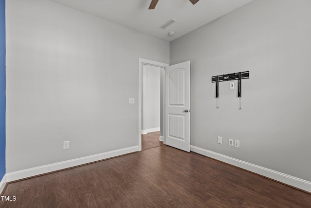 unfurnished room featuring a ceiling fan, baseboards, visible vents, and dark wood-style flooring