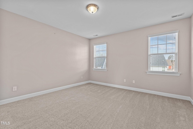 spare room with visible vents, baseboards, and carpet flooring