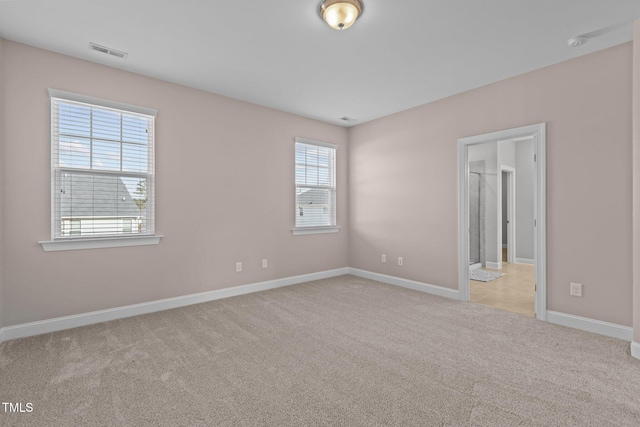 carpeted empty room with baseboards and visible vents