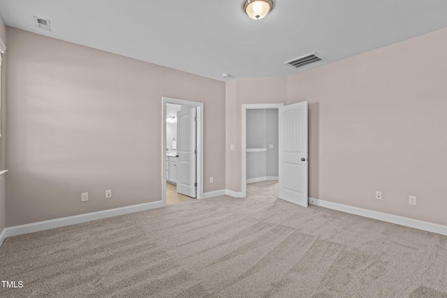 unfurnished bedroom with visible vents, baseboards, carpet, and ensuite bath