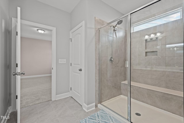 full bathroom featuring tile patterned floors, baseboards, and a shower stall