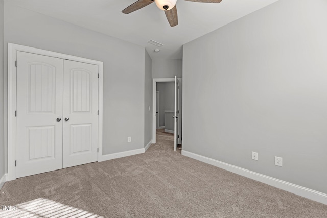 unfurnished bedroom featuring a closet, baseboards, carpet, and ceiling fan