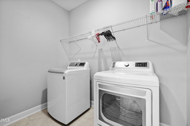 laundry room with light tile patterned floors, baseboards, independent washer and dryer, and laundry area