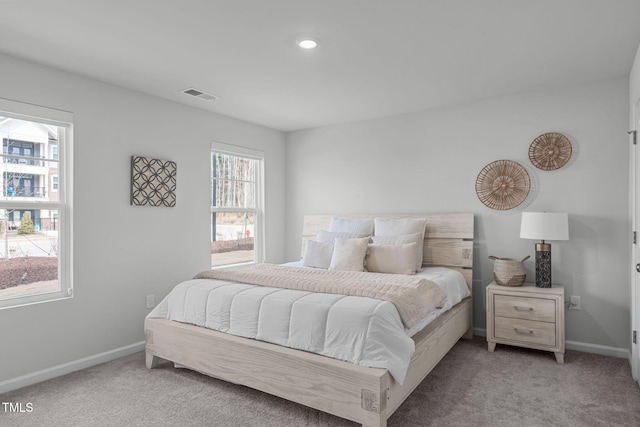 bedroom featuring light carpet, visible vents, and baseboards