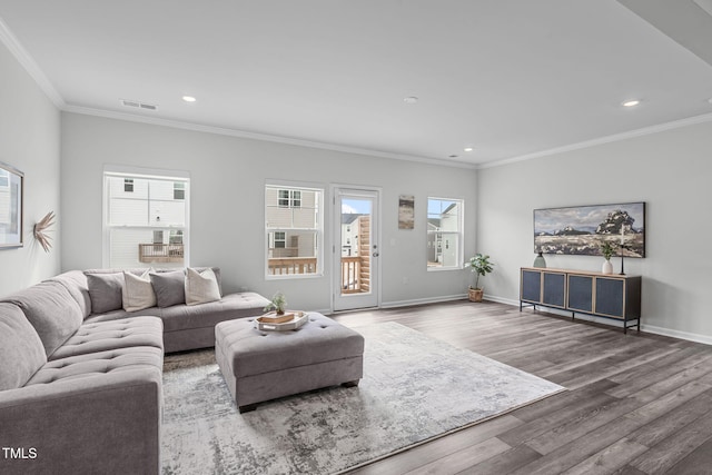 living area featuring ornamental molding, wood finished floors, visible vents, and baseboards