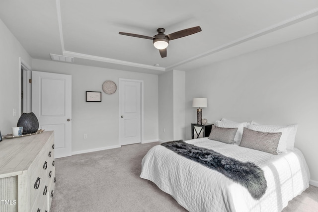 carpeted bedroom with ceiling fan, baseboards, visible vents, and a raised ceiling