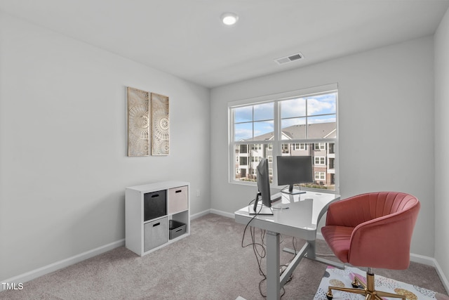 home office featuring light colored carpet, visible vents, and baseboards