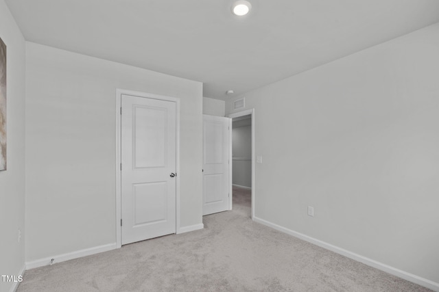 unfurnished bedroom with carpet, visible vents, and baseboards