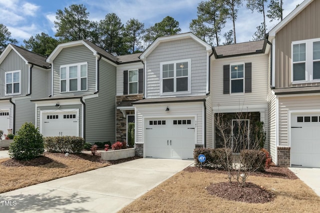 view of front of house with a garage, stone siding, and concrete driveway