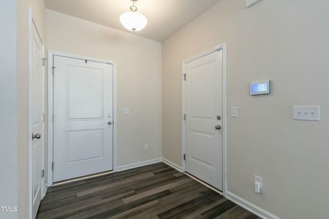 entryway featuring dark wood-type flooring and baseboards