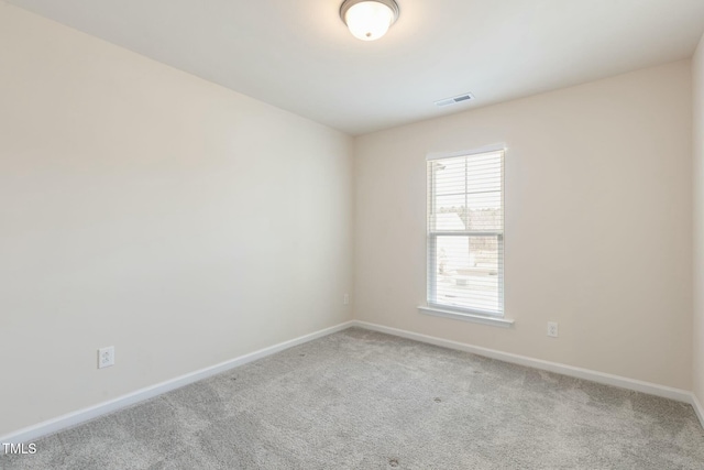 spare room featuring carpet flooring, visible vents, and baseboards