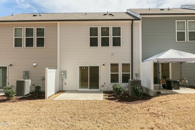 rear view of house featuring a yard, central AC unit, and a patio