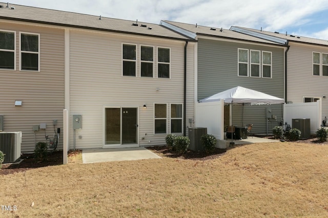 rear view of house featuring a patio area, a lawn, and central air condition unit