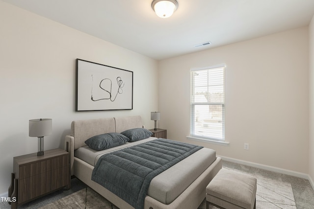 bedroom with dark colored carpet, visible vents, and baseboards