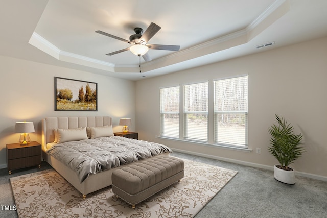 bedroom featuring carpet floors, a raised ceiling, visible vents, and ornamental molding