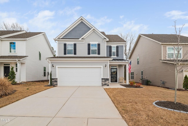 view of front of house with concrete driveway, central AC unit, a standing seam roof, a garage, and stone siding