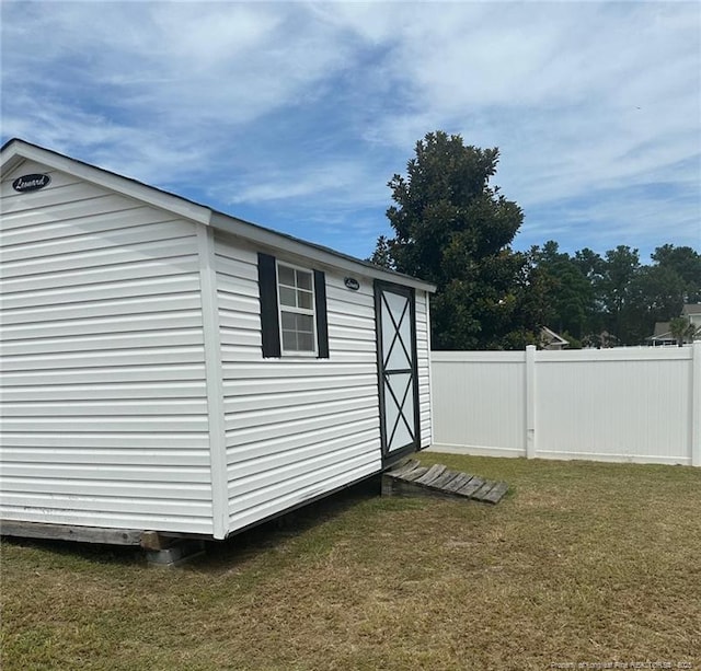 view of shed featuring fence