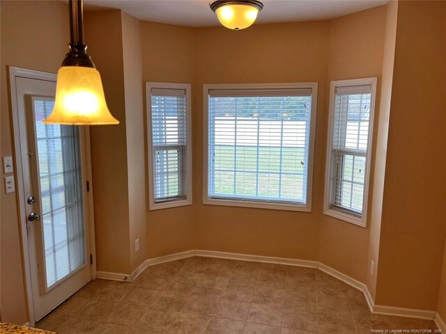 doorway to outside featuring light tile patterned flooring and baseboards