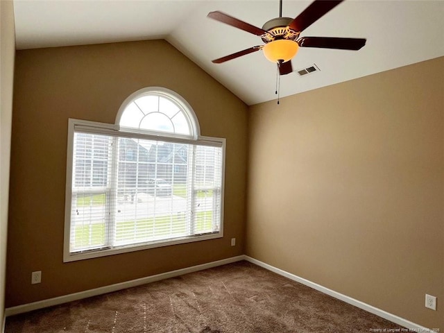 unfurnished room with carpet, lofted ceiling, visible vents, a ceiling fan, and baseboards