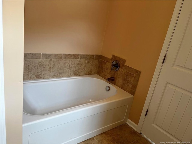 bathroom with a garden tub and tile patterned floors