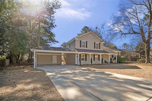 traditional-style home with a carport, a porch, and concrete driveway