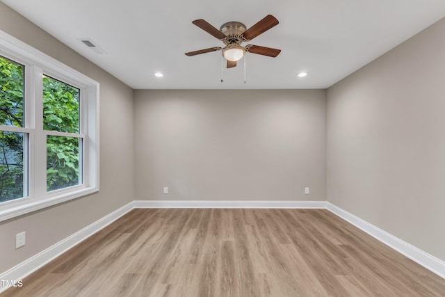 empty room with light wood finished floors, recessed lighting, visible vents, and baseboards