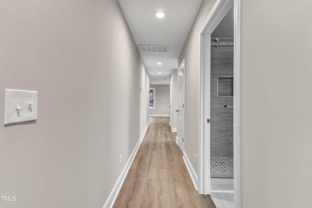 hallway with light wood-style floors, recessed lighting, visible vents, and baseboards