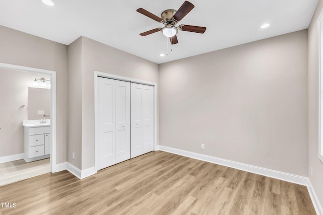 unfurnished bedroom with recessed lighting, a closet, light wood-type flooring, and baseboards