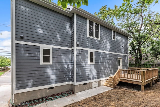 view of side of property featuring a deck and crawl space