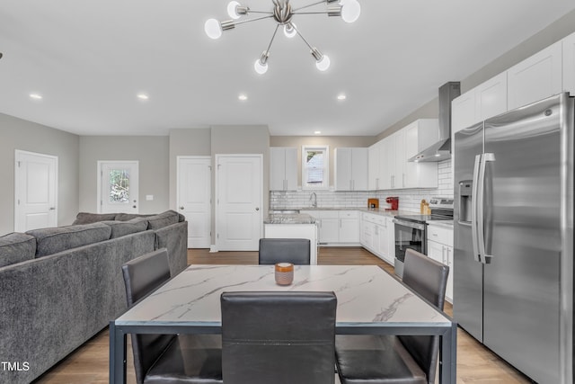 dining area featuring a wealth of natural light, light wood finished floors, and recessed lighting