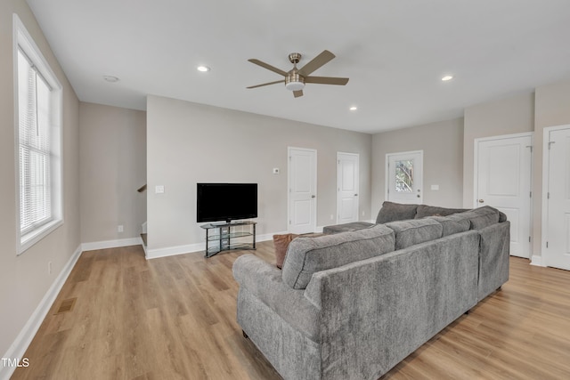 living area with light wood finished floors, baseboards, visible vents, and a wealth of natural light