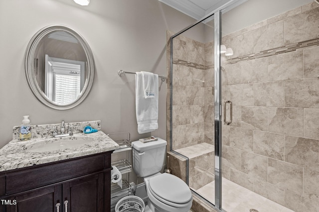 full bathroom featuring vanity, a shower stall, and toilet