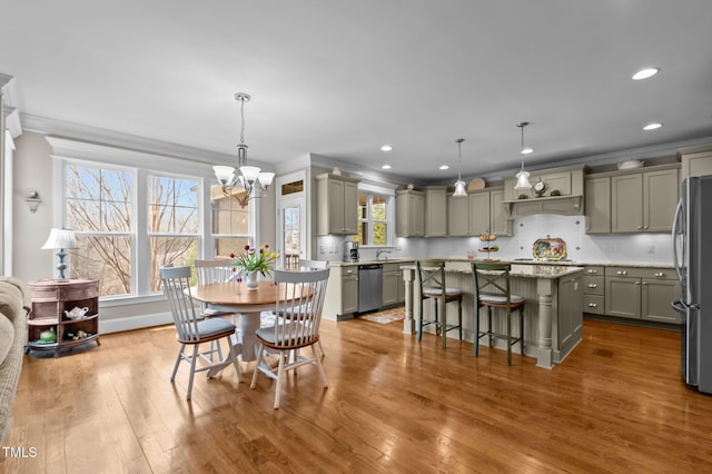 dining room featuring a chandelier, recessed lighting, crown molding, and wood finished floors