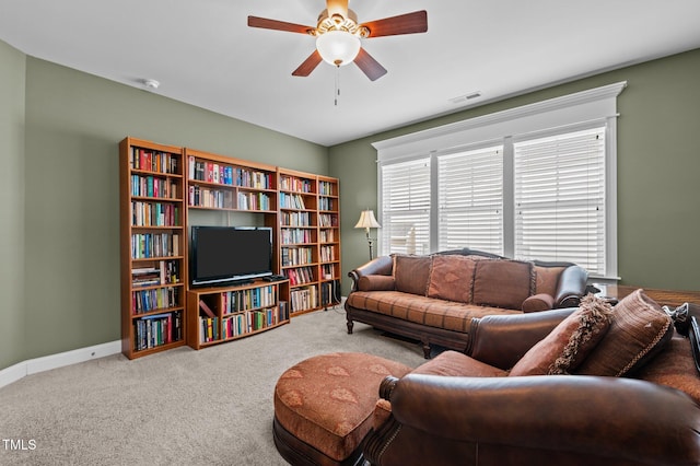 carpeted living area featuring a ceiling fan, visible vents, and baseboards