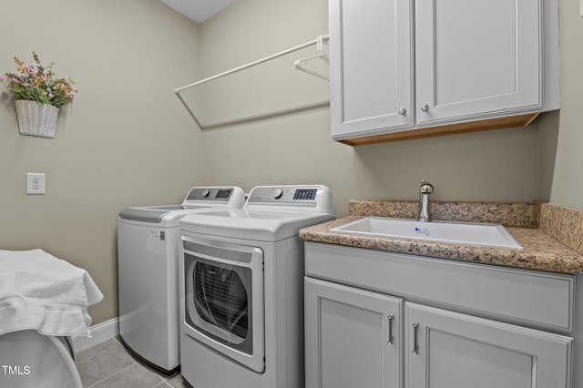 laundry room featuring washer and clothes dryer, light tile patterned floors, cabinet space, and a sink