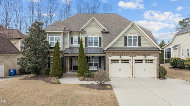 view of front of home with a shingled roof, covered porch, a garage, stone siding, and driveway