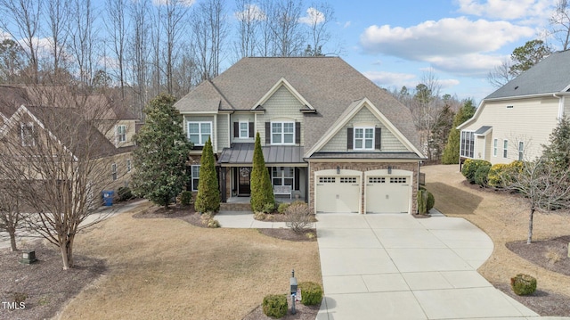 craftsman-style house with driveway, a standing seam roof, a shingled roof, stone siding, and a garage