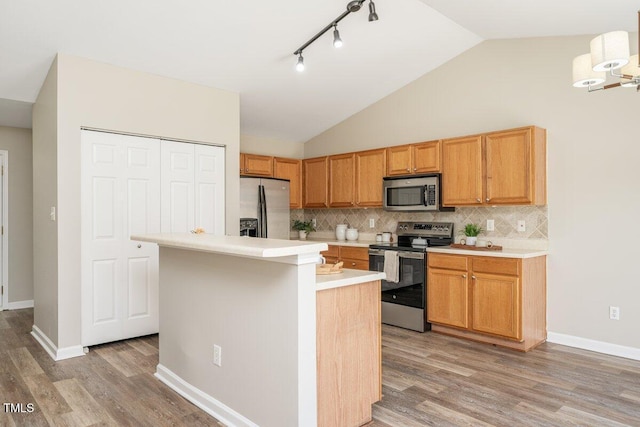 kitchen with decorative backsplash, light countertops, light wood finished floors, and appliances with stainless steel finishes