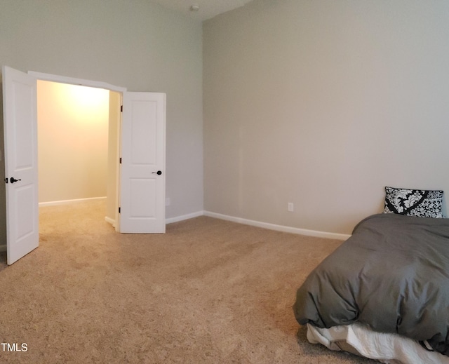 bedroom featuring baseboards and light carpet